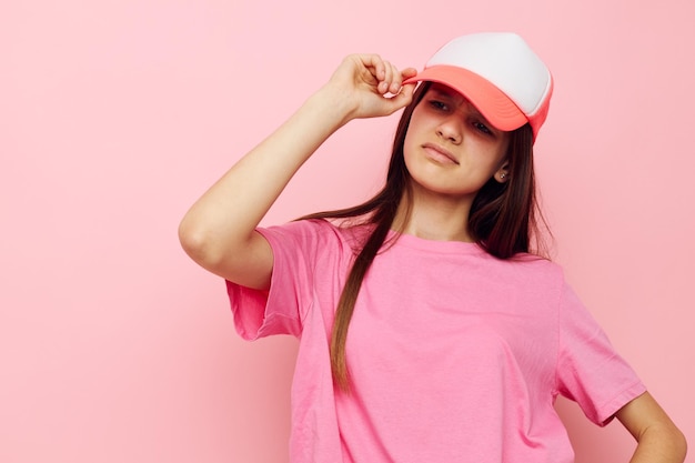 Una joven alegre con una gorra en la cabeza con una camiseta rosa