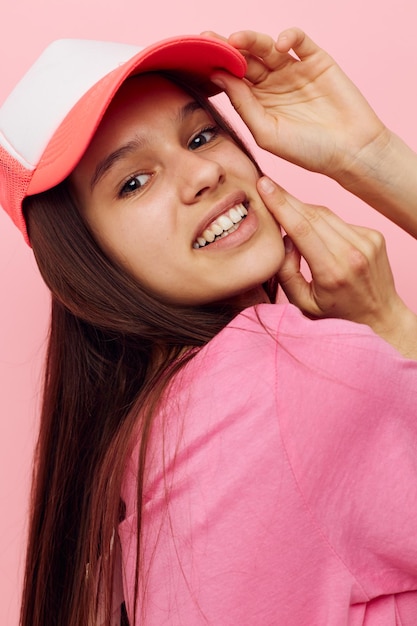 Una joven alegre con una gorra en la cabeza con una camiseta rosa