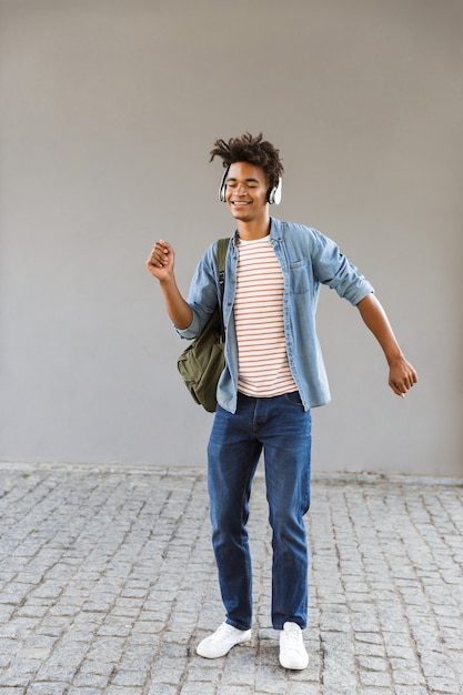 Joven alegre con mochila al aire libre