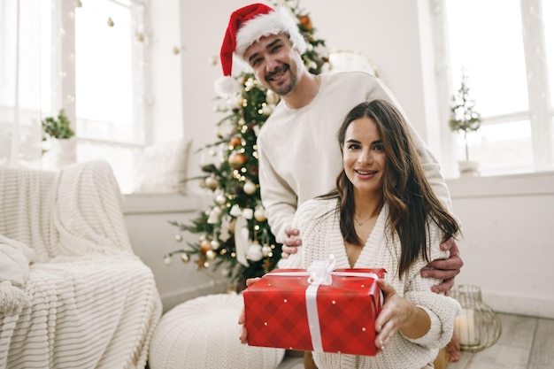 Joven alegre pareja enamorada del presente para navidad