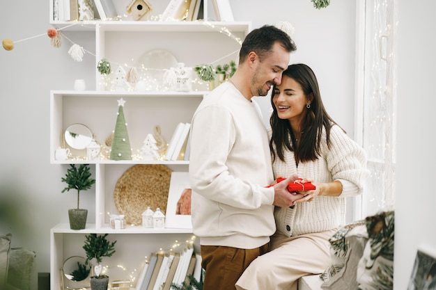 Joven alegre pareja enamorada del presente para navidad