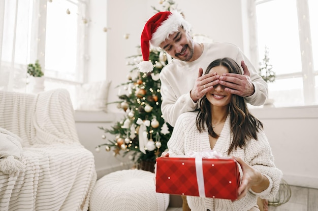 Joven alegre pareja enamorada de presente para navidad