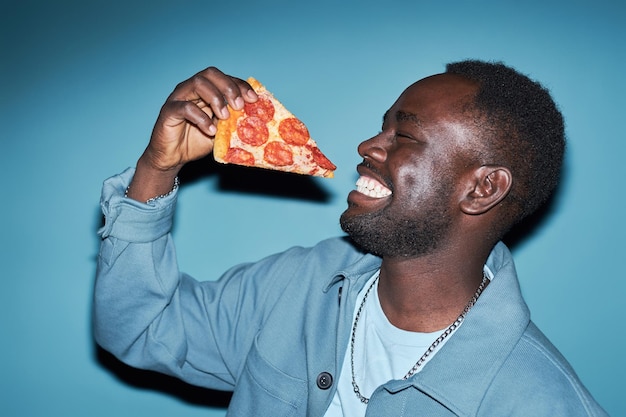 Joven alegre con una rebanada de pizza