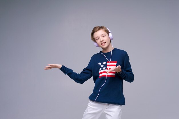 Foto joven alegre en suéter azul con bandera de américa está escuchando música