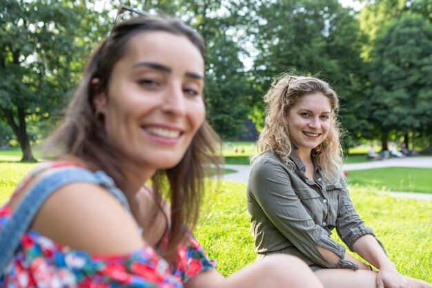 Foto una joven alemana rubia sonríe a la cámara con su amiga en primer plano fuera de foco