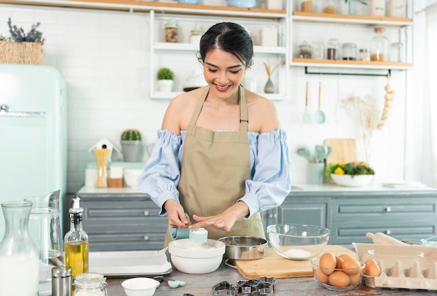 Joven ama de casa asiática en la cocina cocinando la masa de panadería casera