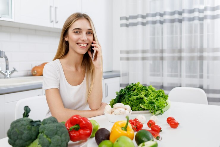 Joven ama de casa intercambiando recetas de cocina a través de un teléfono inteligente