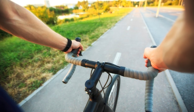 El joven anda en bicicleta por la ciudad.