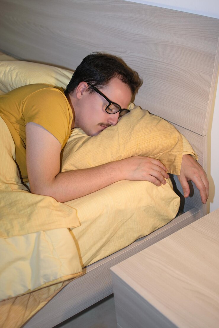 Joven con anteojos negros durmiendo en la cama
