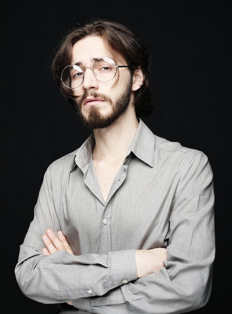 Joven con anteojos sobre fondo negro Concepto de estilo de vida