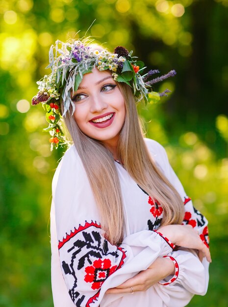 Una joven de apariencia eslava con una corona de flores silvestres a mediados de verano.