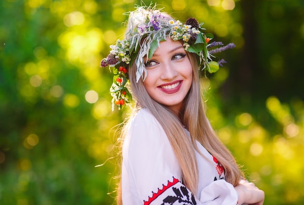 Una joven de apariencia eslava con una corona de flores silvestres a mediados de verano.