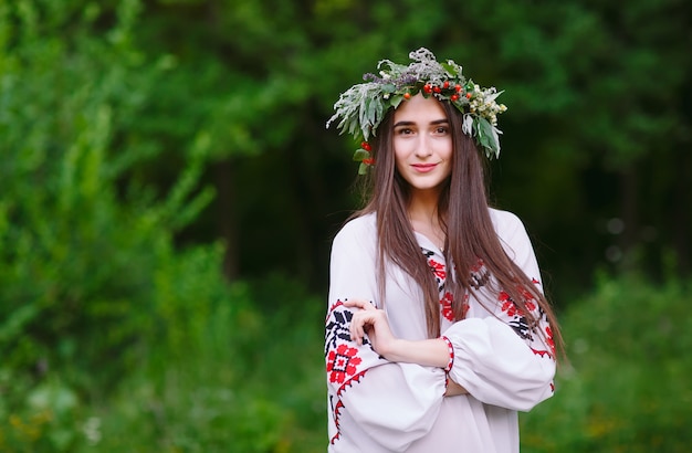 Una joven de apariencia eslava con una corona de flores silvestres en el verano.