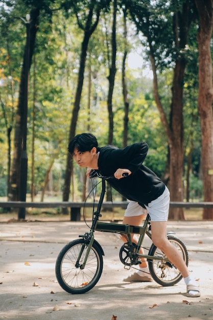 Joven apuesto y feliz con bicicleta en una calle de la ciudad Concepto de gente de estilo de vida activo.