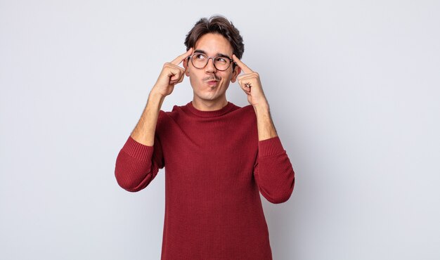 Joven apuesto hispano mirando concentrado y pensando mucho en una idea, imaginando una solución a un desafío o problema