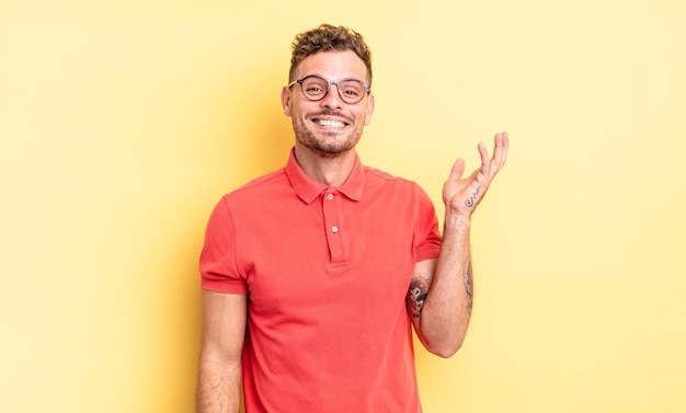 Joven apuesto hispano que se siente feliz, sorprendido y alegre, sonriendo con actitud positiva, dándose cuenta de una solución o idea