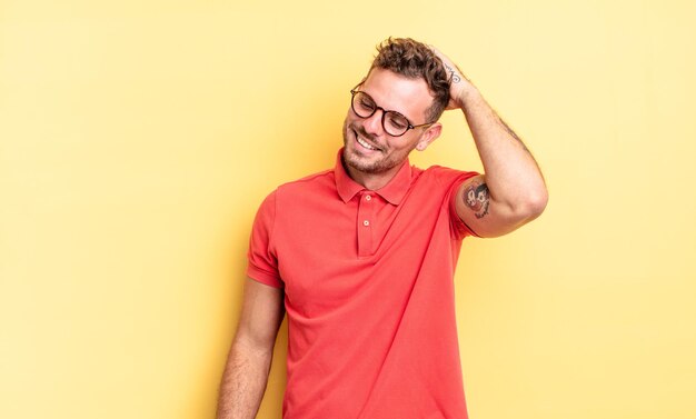 Joven apuesto hombre hispano sonriendo alegre y casualmente tomándose de la mano con una mirada positiva, feliz y confiada