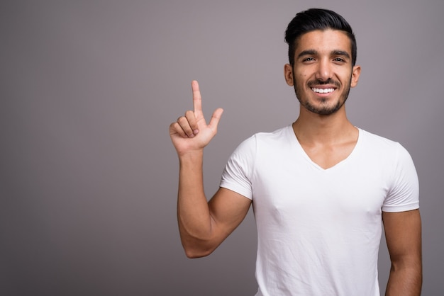 Joven apuesto hombre persa contra el fondo gris