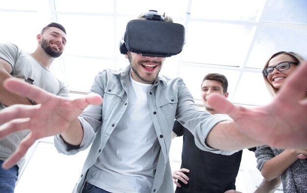 Un joven apuesto con una máscara de realidad virtual señala