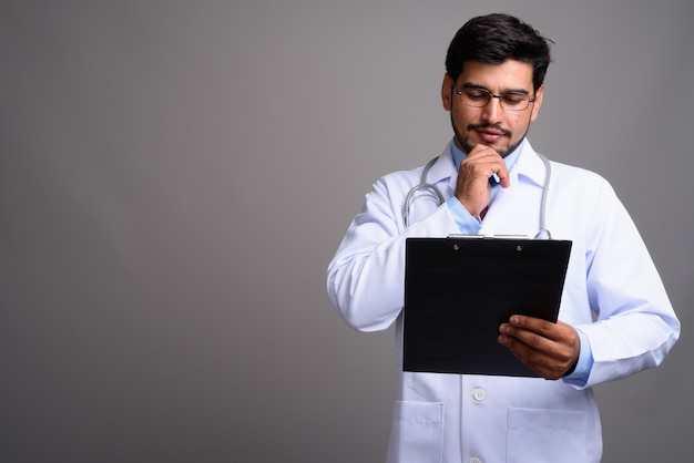 Joven apuesto médico persa barbudo con anteojos