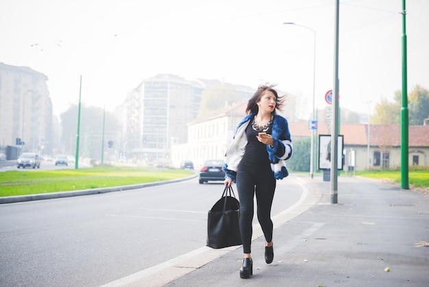 Joven apuesto oriental caminando al aire libre en la ciudad