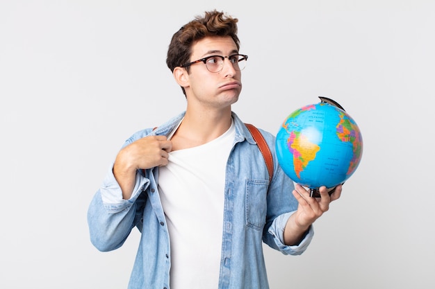 joven apuesto que se siente estresado, ansioso, cansado y frustrado. estudiante sosteniendo un mapa del globo terráqueo