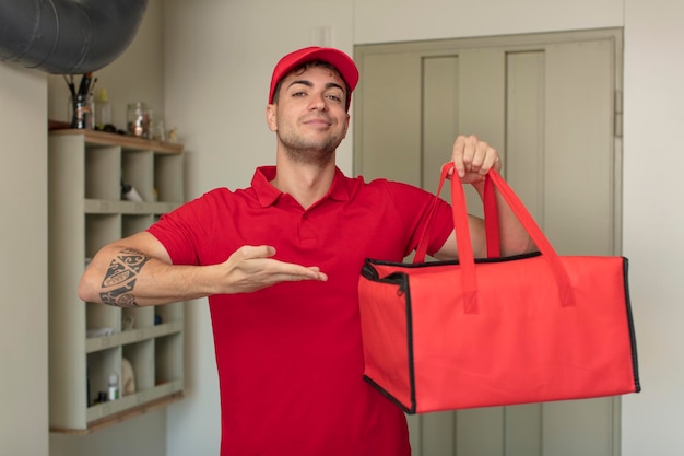 joven apuesto sonriendo alegremente, sintiéndose feliz y mostrando un concepto. concepto de entrega de pizza