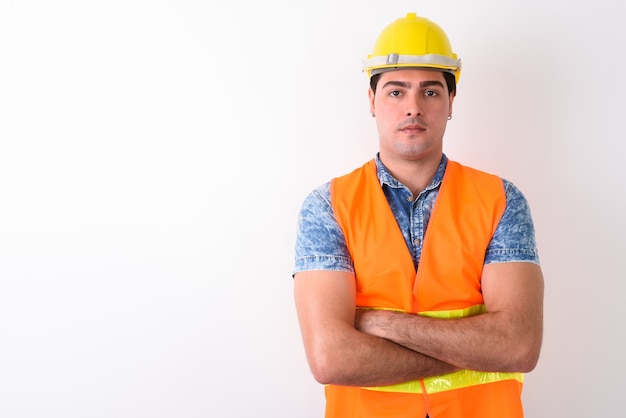 Joven apuesto trabajador de la construcción persa contra bac blanco