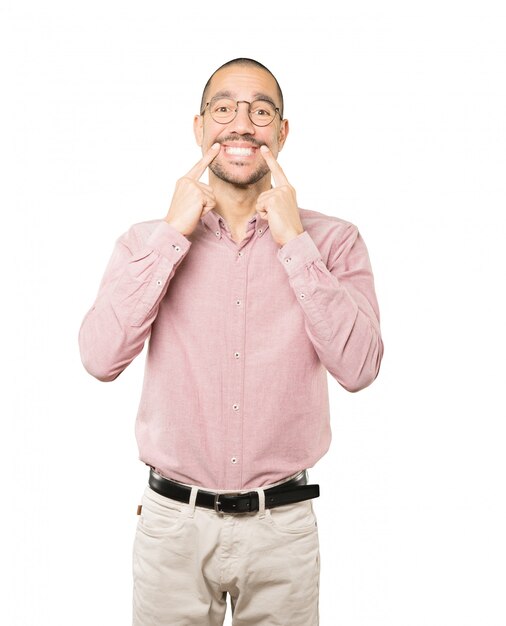 Joven apuntando a sus dientes