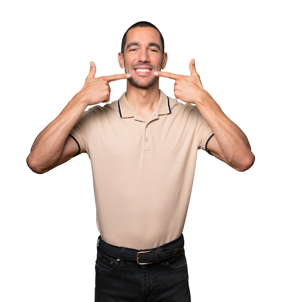 Joven apuntando a sus dientes