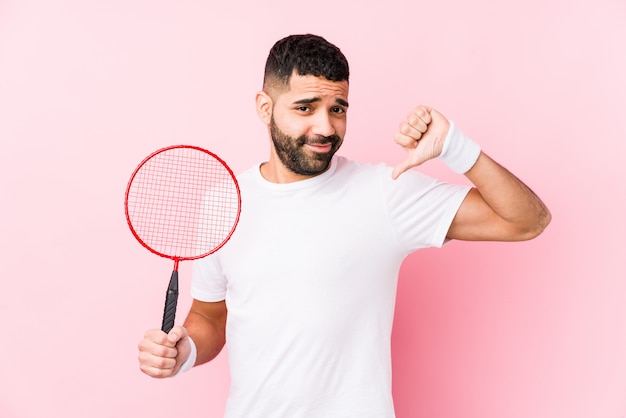 Joven árabe jugando bádminton aislado se siente orgulloso y seguro de sí mismo, ejemplo a seguir.