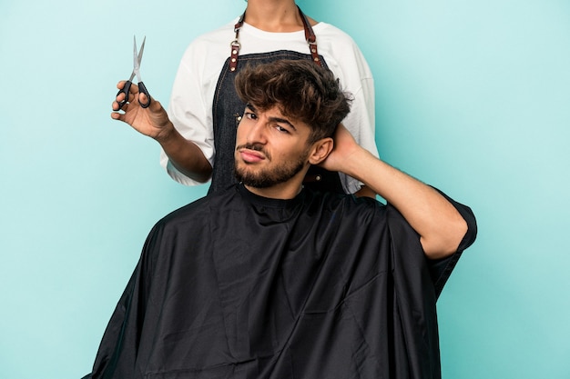 Joven árabe listo para cortarse el pelo aislado sobre fondo azul sorprendido, ella ha recordado una reunión importante.