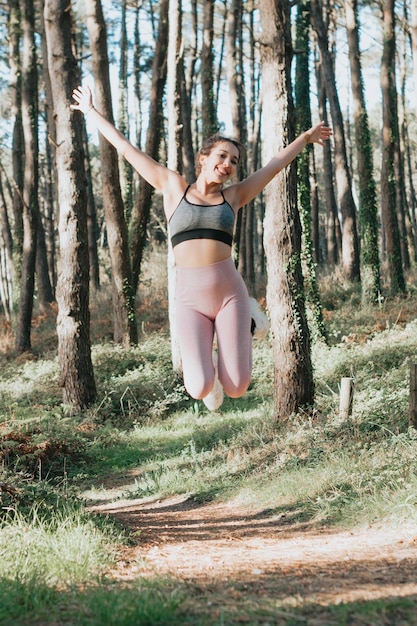 Joven árabe en un parque con ropa deportiva saltando y celebrando el concepto de libertad y despreocupación Estilo de vida saludable haciendo ejercicio al aire libre Súper sonrisa con actitud segura