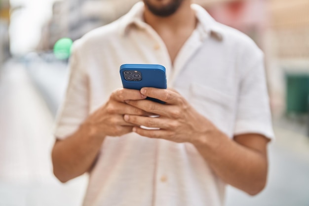 Joven árabe usando un teléfono inteligente en la calle