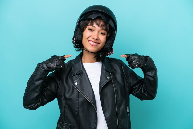 Joven argentina con un casco de motocicleta aislado de fondo azul dando un gesto de pulgar hacia arriba