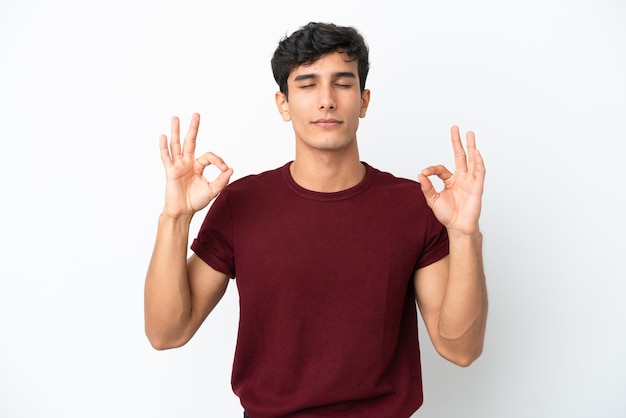 Joven argentino aislado sobre fondo blanco en pose zen