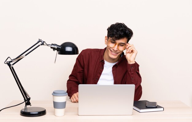 Joven argentino en una mesa con un portátil en su lugar de trabajo