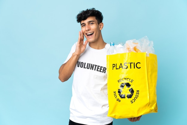 Joven argentino sosteniendo una bolsa llena de plástico gritando con la boca abierta