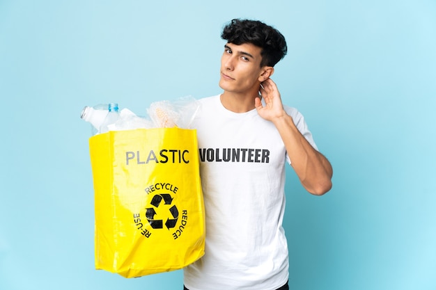 Joven argentino sosteniendo una bolsa llena de plástico teniendo dudas