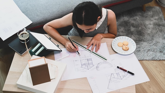 Foto joven arquitecta trabajando en planos en casa