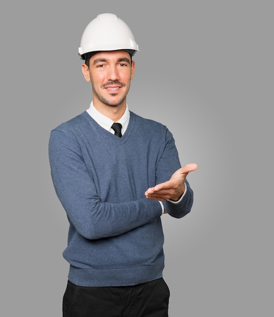 Foto joven arquitecto haciendo un gesto de bienvenida con la mano