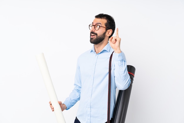 Joven arquitecto hombre con barba sobre fondo blanco aislado pensando una idea apuntando el dedo hacia arriba