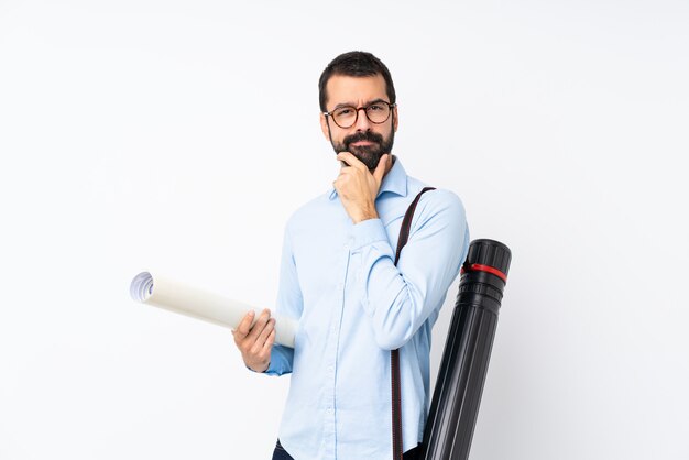 Joven arquitecto hombre con barba sobre pensamiento de pared blanca aislada