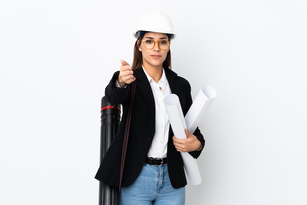 Joven arquitecto mujer caucásica con casco y sosteniendo planos