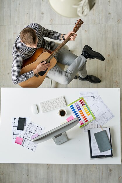 Joven arquitecto tocando la guitarra