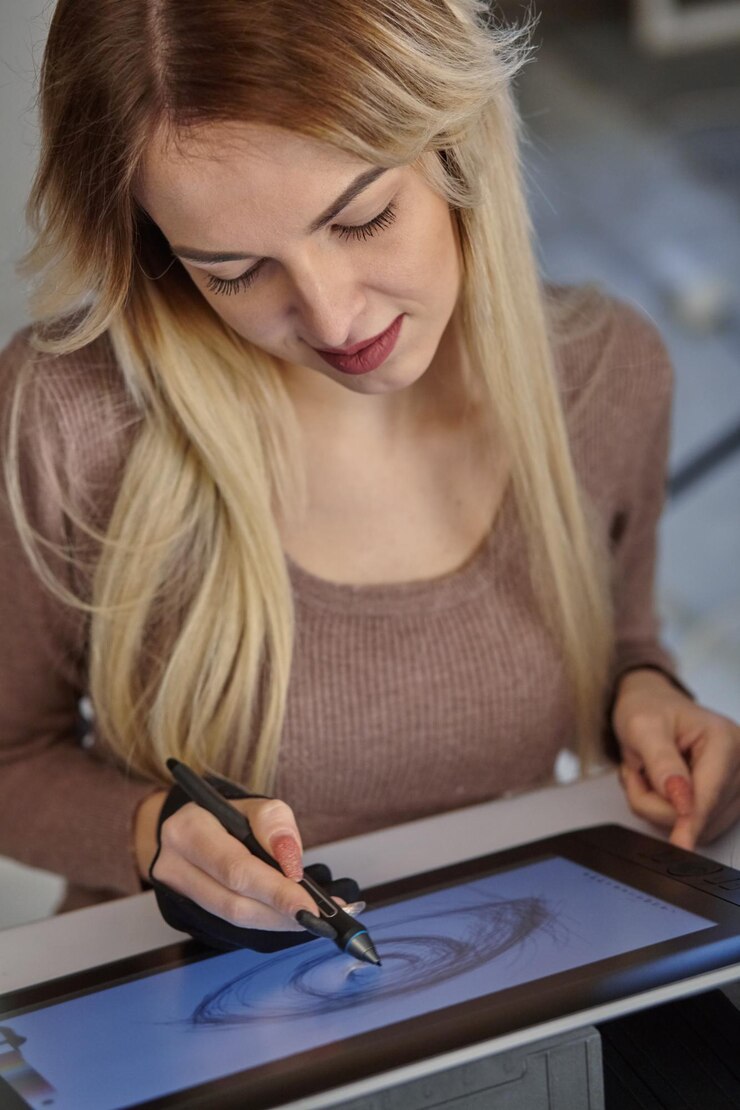 Foto la joven artista dibuja un bolígrafo digital en una tableta profesional en su estudio