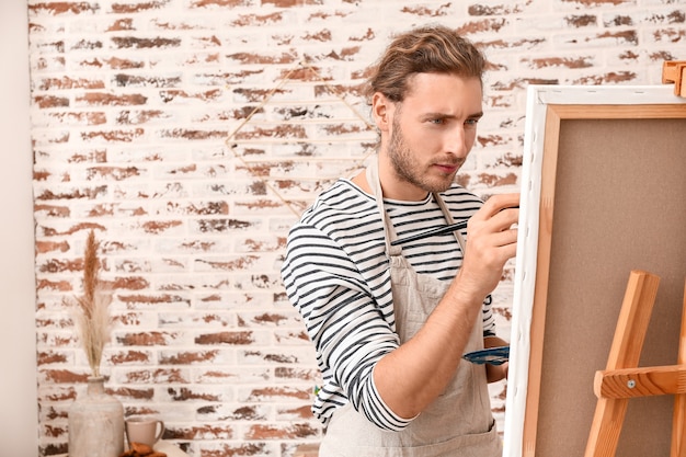 Joven artista masculino pintando en casa