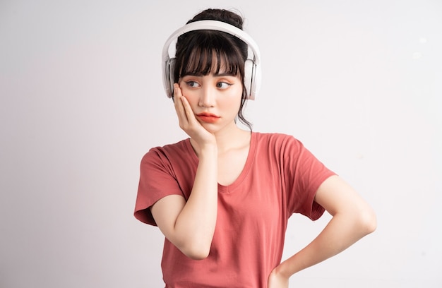 Joven asiática con auriculares inalámbricos para escuchar música