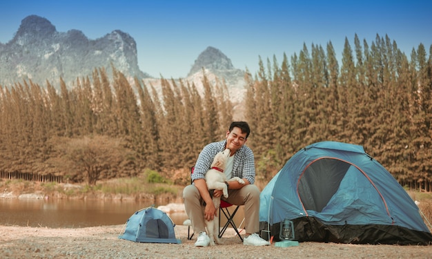 Foto joven asiática en camisa azul con lindo perrito acampando en la vista de la montaña de lake hill feliz y disfruta de la vida