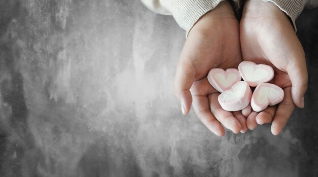 Joven asiática con caramelo de corazón en las manos. Día de San Valentín.